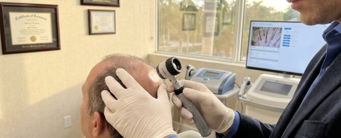 Hair transplant Florida specialist examining patient scalp in modern Boca Raton medical office