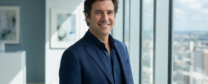 Confident professional man in modern office representing no shave FUE hair transplant discretion