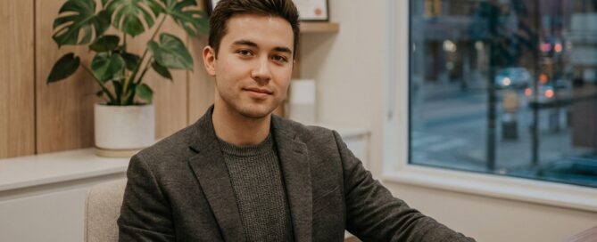 Young man in a modern consultation room reflecting patience — illustrating hair transplant age minimum recommendation guidance.